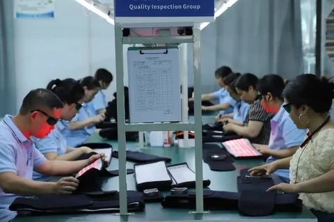 Staff checking illuminated flexible light products at facing workstations