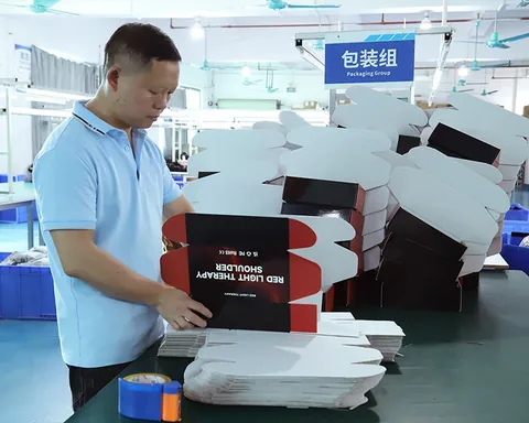 Trabajador preparando cajas de embalaje impresas.