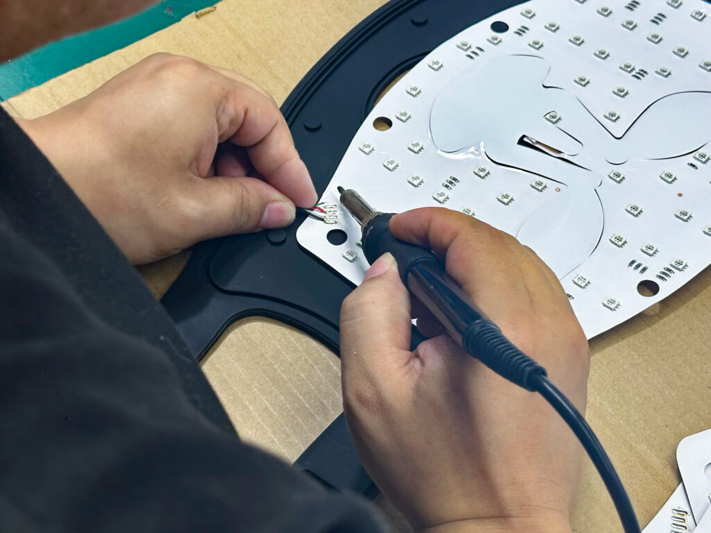 Hands assembling the internal light board of a mask