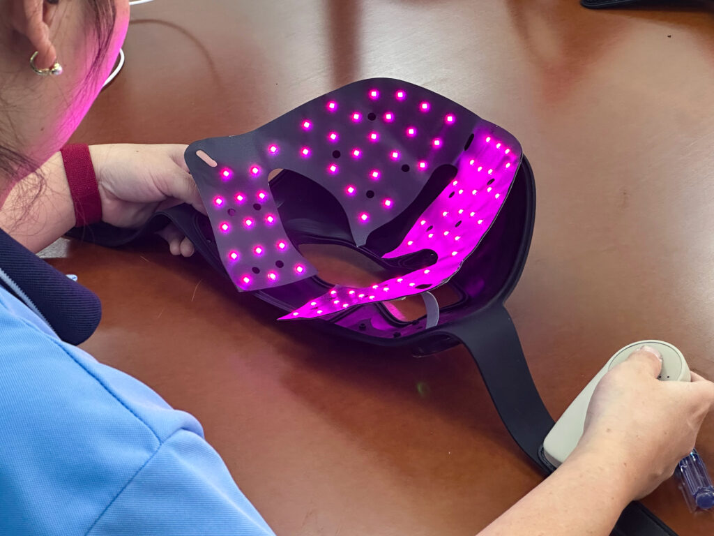 Hands holding an illuminated flexible mask during a factory check