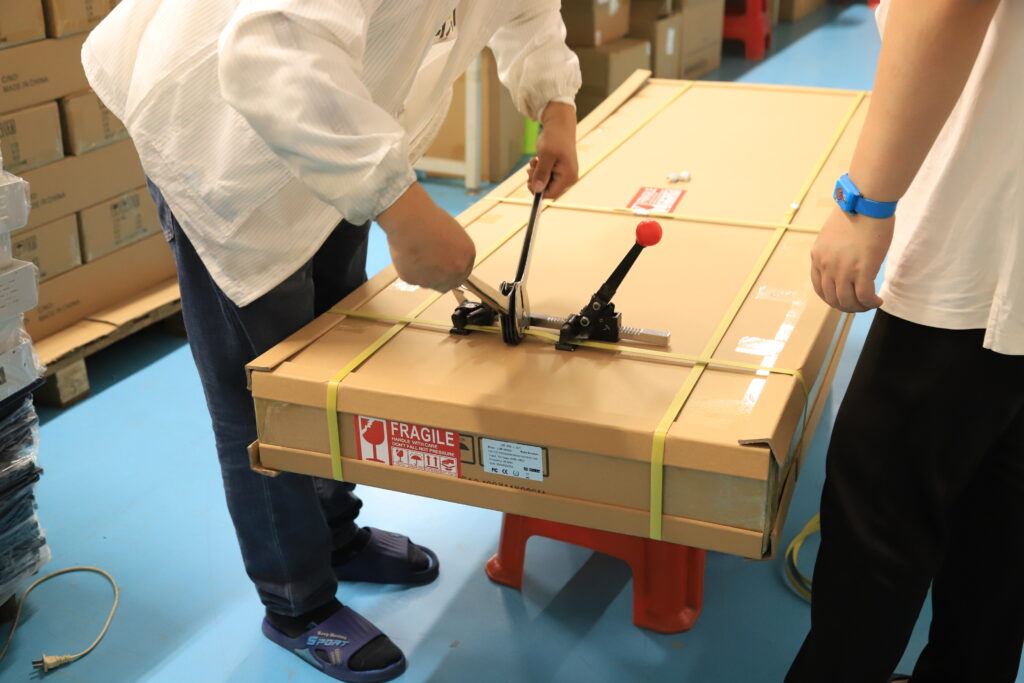 Staff preparing a carton for a light panel
