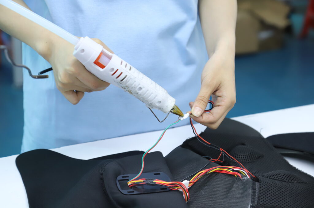 Hands securing internal wiring in a flexible product component