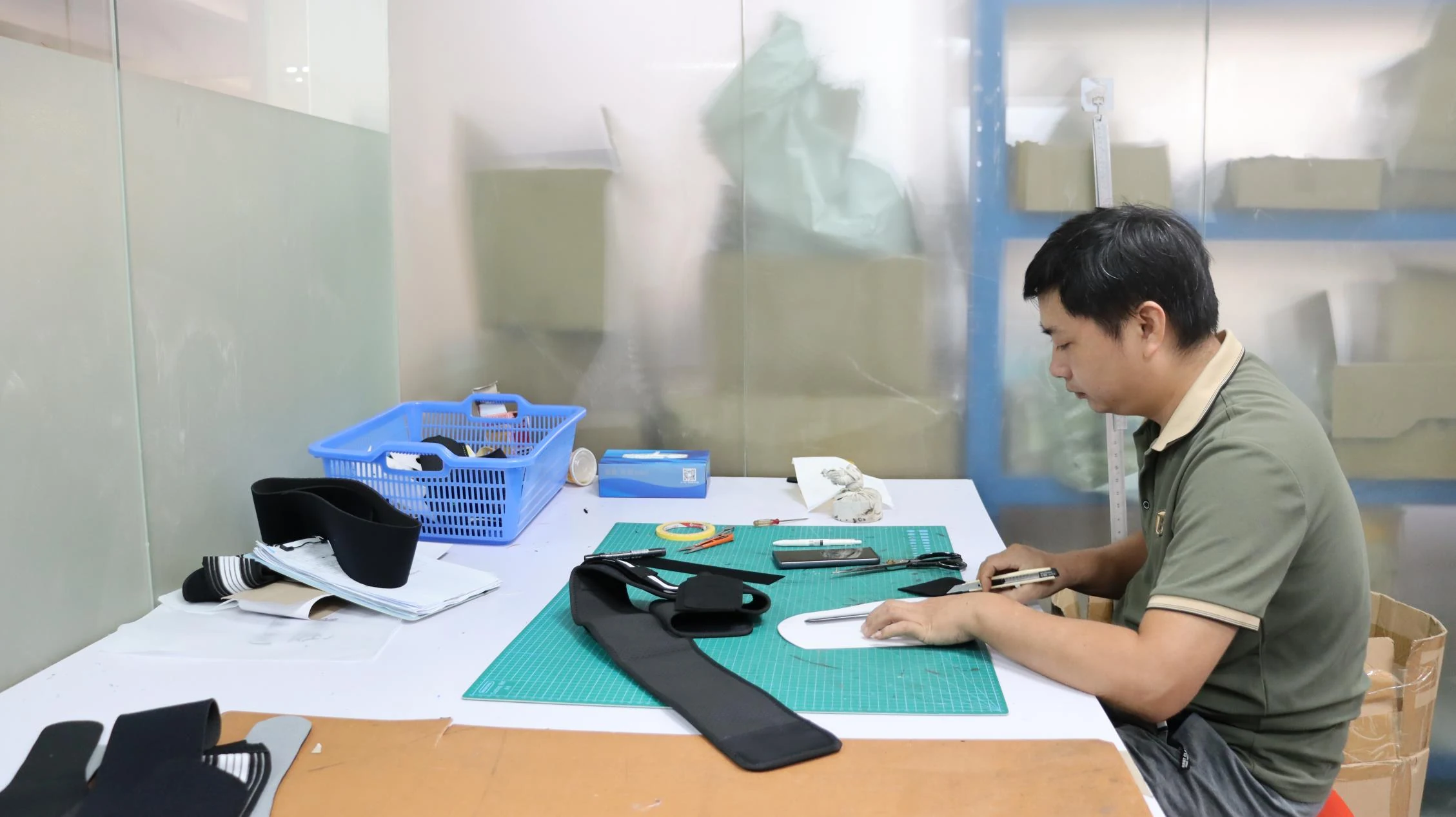 Worker preparing fabric patterns and materials at a work table
